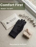 Pair of black Aerynx winter gloves on a flat surface, showcasing the three-finger touchscreen capability and silicone palm gr