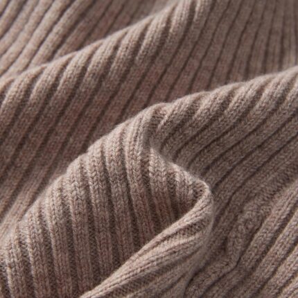 Close-up of a light camel 100% merino wool cuffed beanie hat, showcasing its soft knit texture.