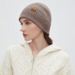 Close-up of a light camel 100% merino wool cuffed beanie hat, showcasing its soft knit texture.