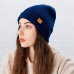Close-up of a knitted FUQILA Merino wool cuff beanie hat in a solid color, showcasing its soft texture.