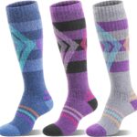 Three pairs of striped Welwoos Merino wool thermal ski socks in blue, purple, and grey, folded neatly.